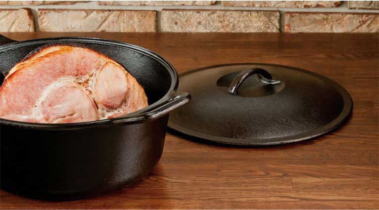 A traditional bare cast iron dutch oven with lid from Lodge Manufacturing.