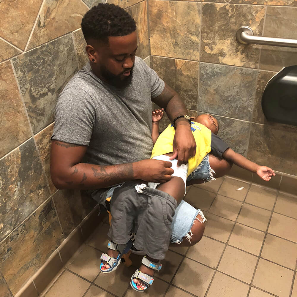 Donte Palmer changing son's diaper without a changing station