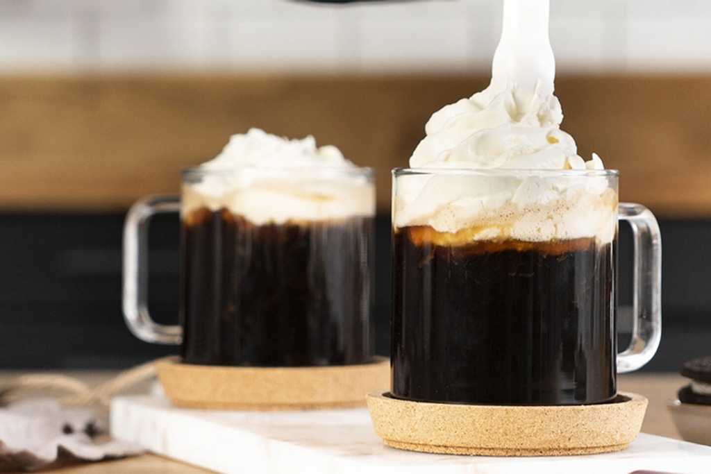 Whipped cream in a coffee beverage created from iSi whipping siphon.