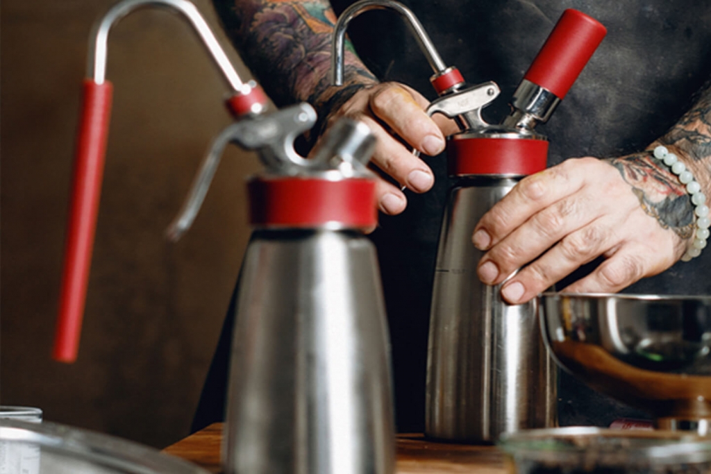 Chef Messina quickly prepares a whipping siphon for rapid infusion.