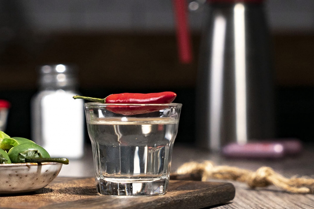 Jalapeno peppers with a glass of tequila.