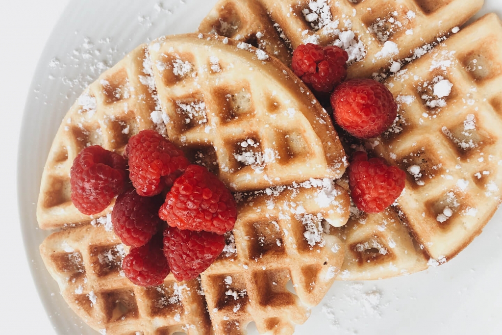 Waffles with fresh raspberries and powdered sugar.