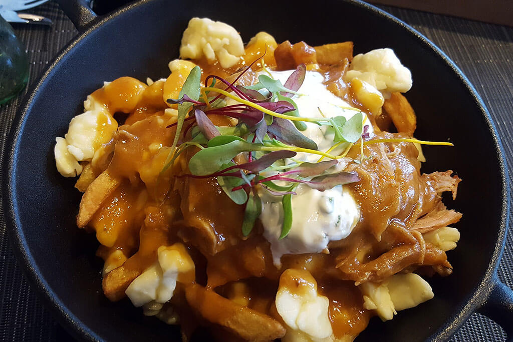 Poutine with barbequed pork, sour cream, and herbs once served at Le Champlain.