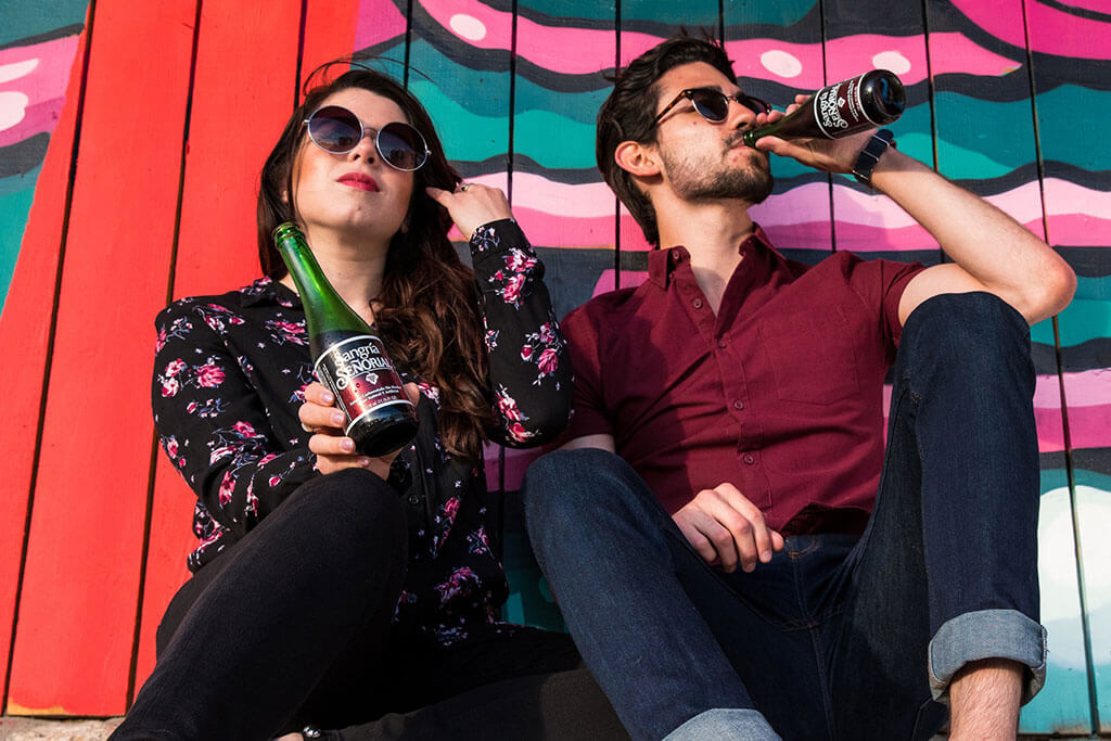 Two friends enjoying a refreshing non-alcoholic sangria beverage.