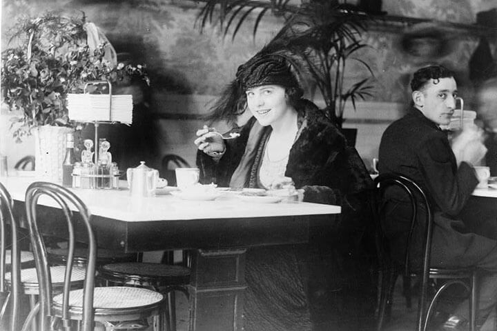 A satisfied customer eats alone at a table and looks happy.