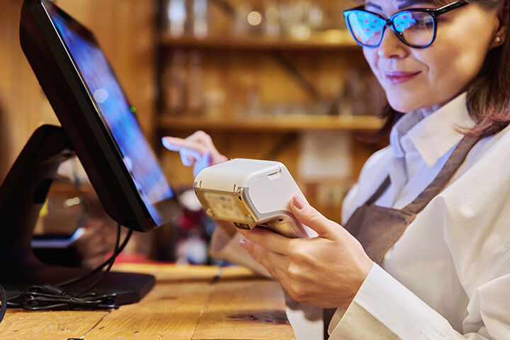 A woman inputs data into the POS system.