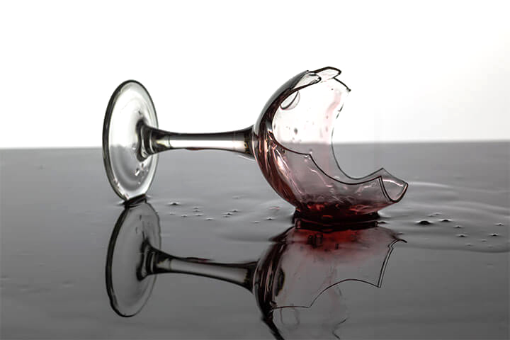 A wine glass lays shattered on the ground, spilling out the hopes and dreams of a million grapes. 