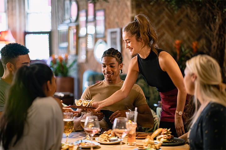 A waitress serves and smiles.