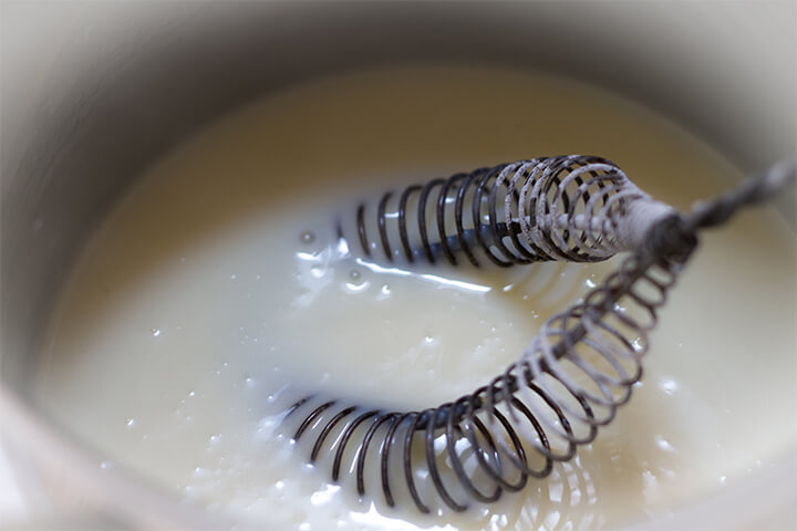 A spiral whisk preparing food. 