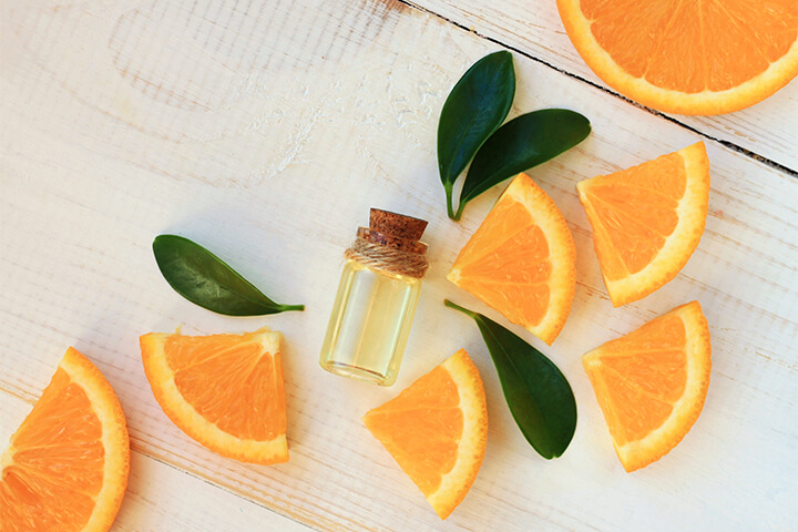 Orange slices with a bottle of fragrance.