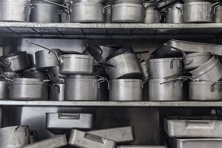 Racks of pots and pans that could use a good cleaning.