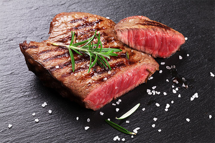 Steak with large salt crystals and garnish.