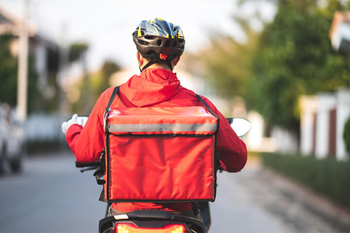 A man on a bike delivers food for C-stores.