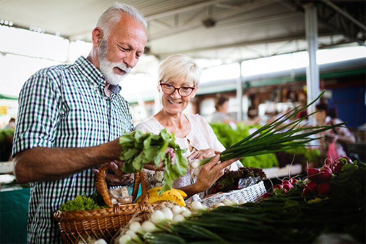 A Baby Boomer couple enjoy their time in the produce section and appear to be very organized. Having witnessed more economic downturns than any other generation, Baby Boomers are price-conscious and appreciate coupons, organized shopping lists, and loyalty programs in grocery stores.