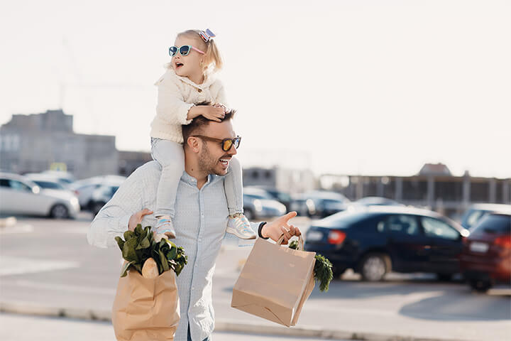 A little girl with very cool sunglasses ride on her dad's shoulders. Young children enjoy picking out items, especially fruits and vegetables. Grocery stores can get them more involved with kid-friendly touch n' smell stations, fruit and vegetable scavenger hunts, or with colorful signage and fun facts. 