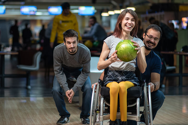 A disabled woman enjoys a night out for bowling.