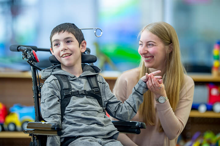A boy in a wheelchair enjoys time spent out with his mom.