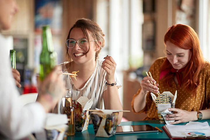 Colleagues enjoy asian-influenced meal.