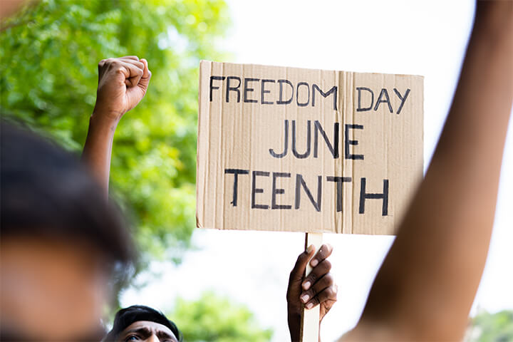 A cardboard sign reading "Freedom Day Juneteenth."