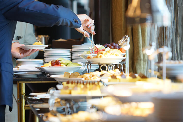 A human chooses amongst a selection of food at a lovely buffet.