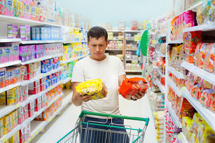 A man looks at two similar products and mutters "der?"