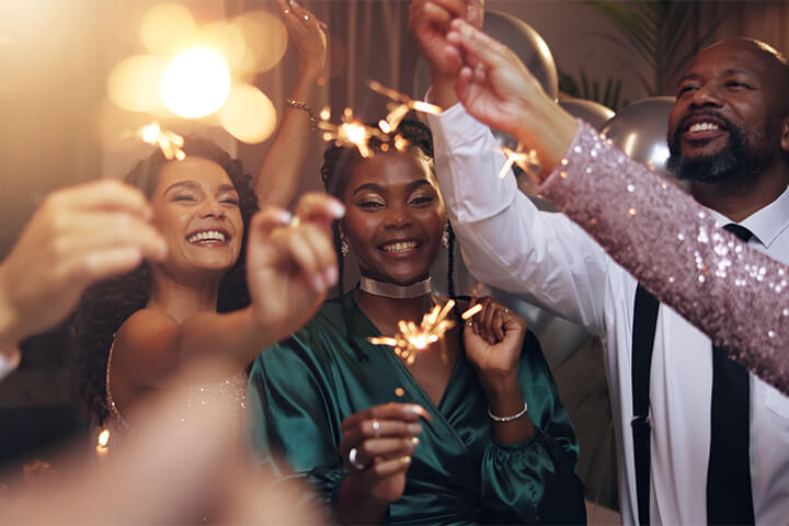 A group of friends play with sparklers. 