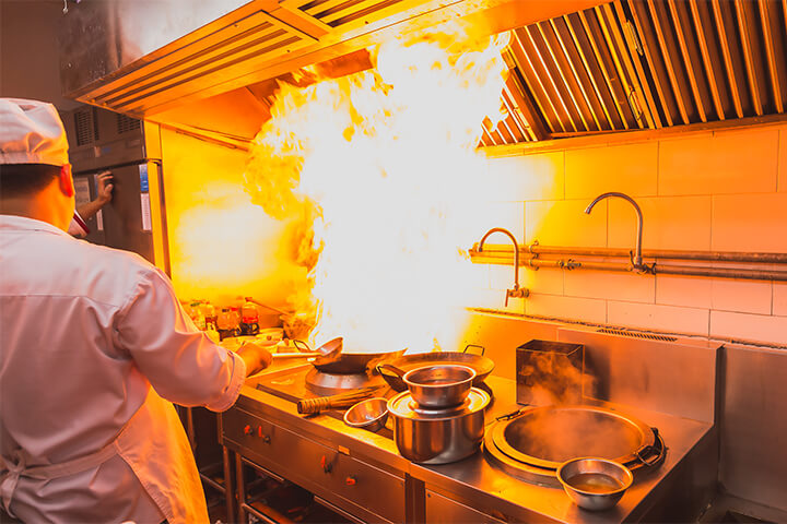 A man cooks under mechanical fixtures. MEP.