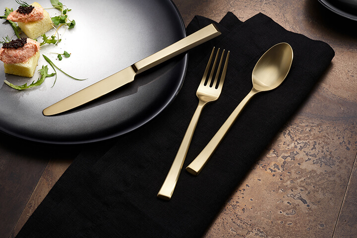 Santorini Satin Gold flatware on a tabletop.