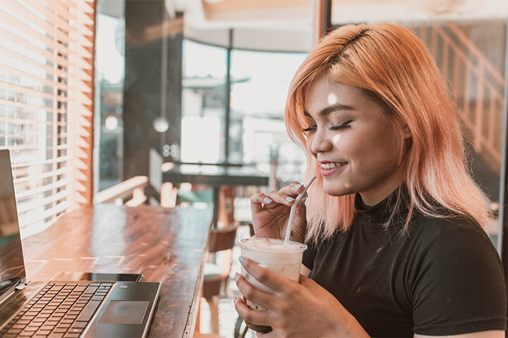 A Gen Z Asian woman enjoys coffee.