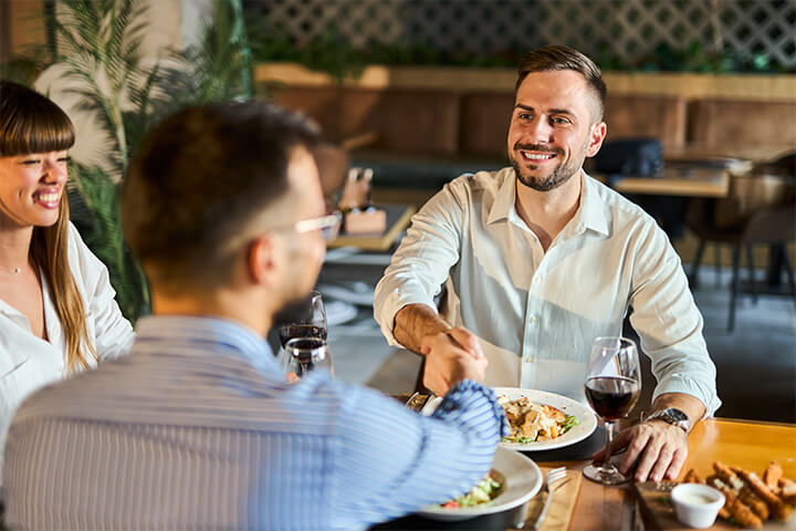Three people get to know each other at a restaurant. 