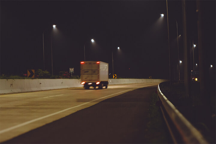 A truck speeds away into the darkness.