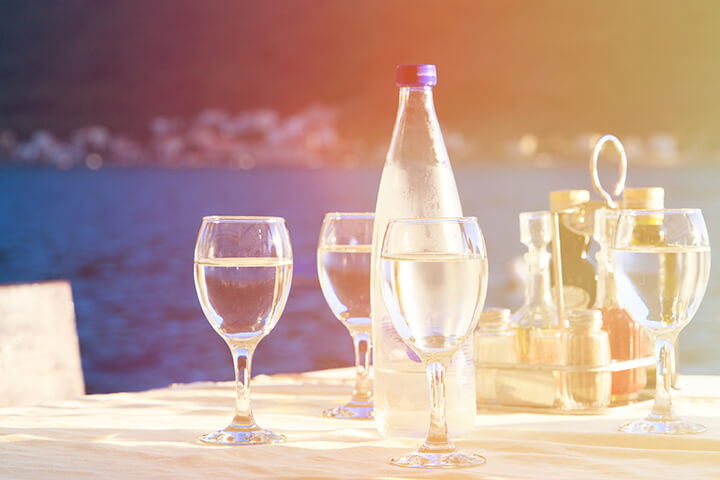 An outdoor setting with stemware and water. 