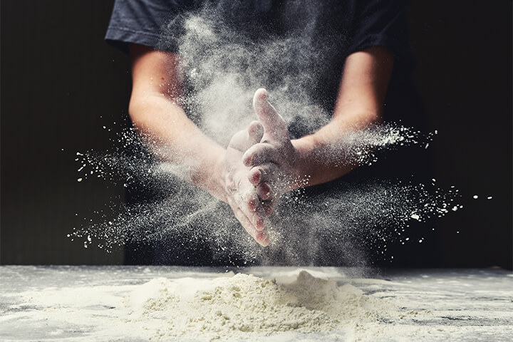 A chef works with flour. 