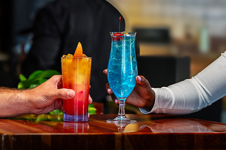 A man and woman sit and look at their mocktails. 
