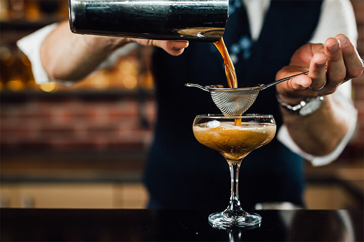 A bartender prepares an espresso martini.