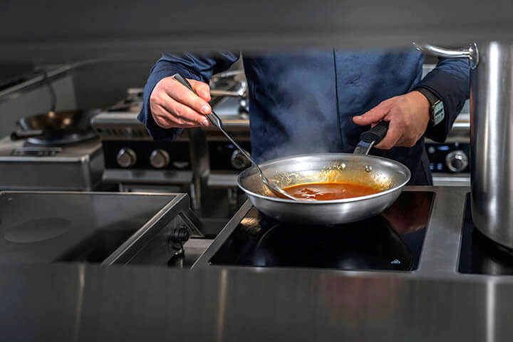A chef prepares a sauce using the new side-by-side induction unit by Vollrath.