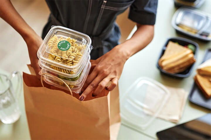 A person puts food into a bag.