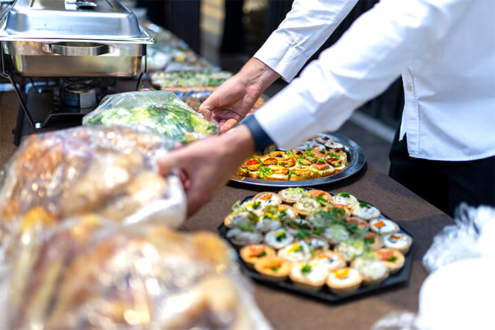 A staff member creates a food display. 