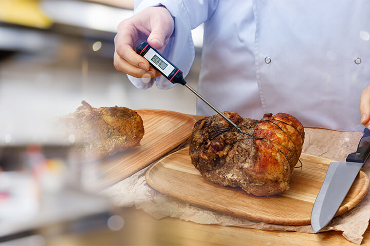 A man uses a thermometer to make sure his food doesn't make anyone sick.
