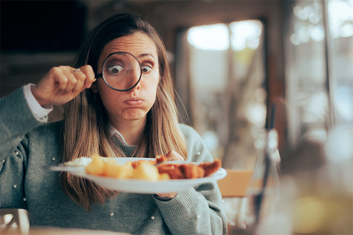 A lady looks for pathogens in food. She is afraid the filter was not changes in the combi oven.