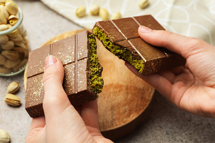 A person breaks open a Dubai chocolate bar.