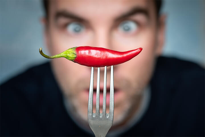A man stares at a pepper.