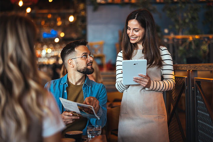 A man asks his server a question about the menu.