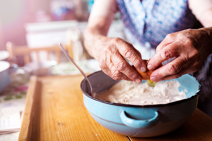 Grandma cracks an egg.