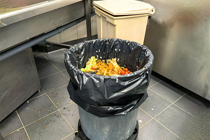 A trash bin full of wasted food.